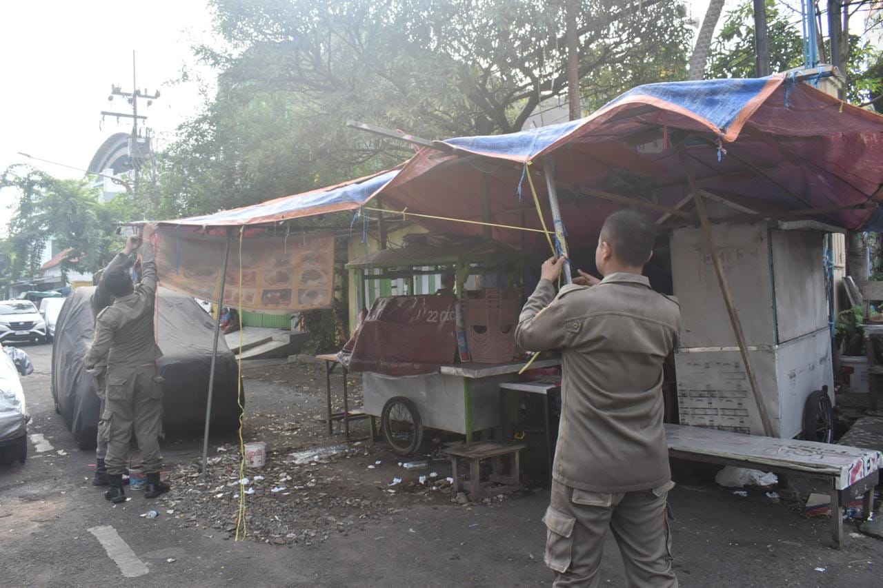 Petugas Satpol PP Kota Surabaya saat menertibkan PKL di Jalan Pegirian, Sabtu (26/5). (Humas Pemkot Surabaya). - Image
