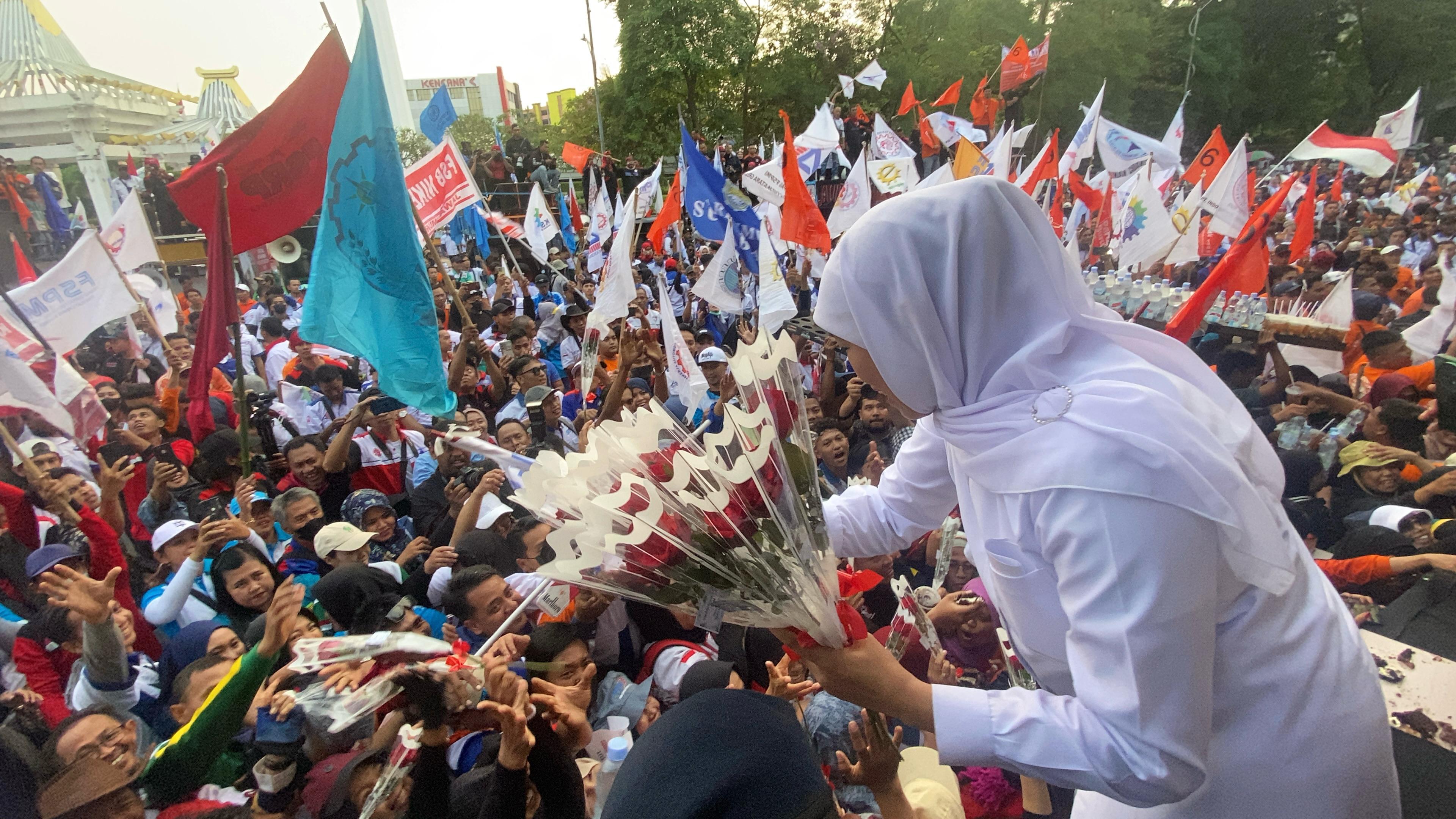 Gubernur Khofifah saat membagikan bunga mawar merah kepada massa buruh, sebagai tanda penghargaan dan solidaritas. (Juliana Christy / JawaPos.com) - Image