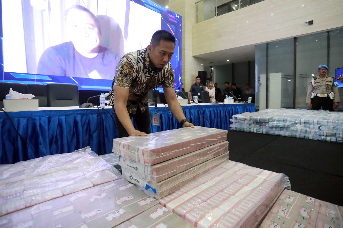 Petugas memeriksa barang bukti kasus judi online saat konferensi pers di Gedung Bareskrim Polri, Jak