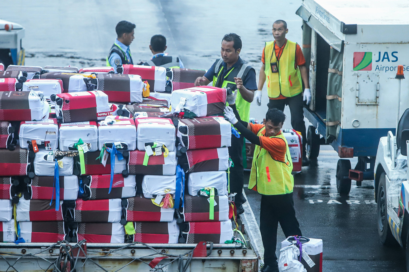 Petugas menata koper Jamaah calon haji menuju pesawat saat pemberangkatan di Terminal 1 Bandara Inte