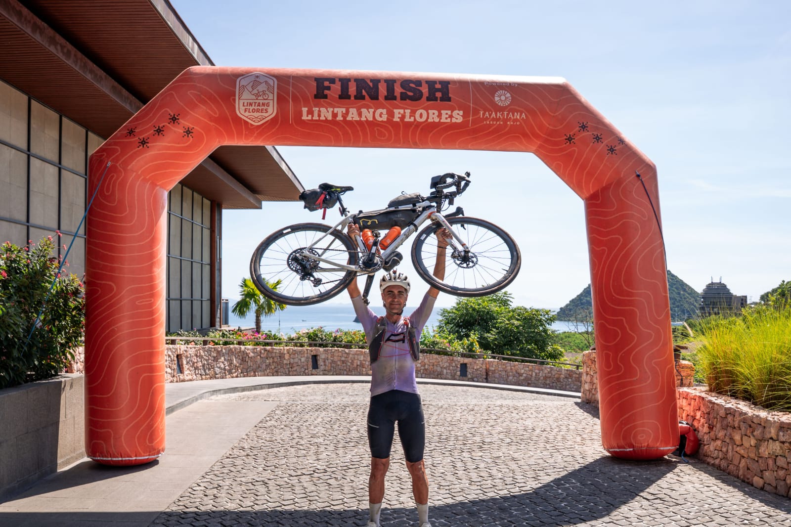 Finisher pertama Lintang Flores 2025 Dr. Stephen Lane berpose di garis finish di Ta - Image