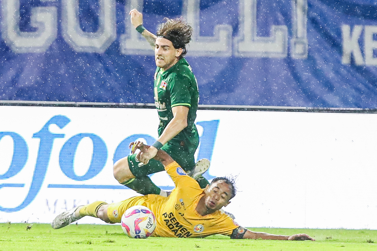 Pemain Persebaya, Dejan Tumbas berebut bola dengan pemain Semen Padang, Rosad Setiawan pada lanjutan Liga 1 di Stadion Gelora Bung Tomo, kemarin (11/5). Persebaya dihatan imbang Semen Padang dengan skor (1-1). RIANA SETIAWAN/ JAWA POS - Image