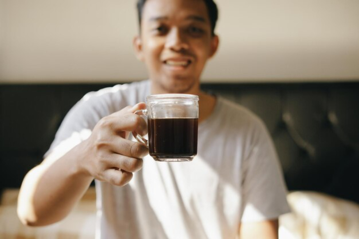seseorang yang memiliki kebiasaan meminum kopi hitam tanpa gula (Freepik/galihyogaw) - Image