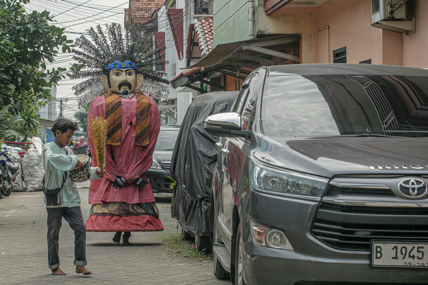Seorang pengamen Ondel-Ondel melintas di daerah Cibodas, Kota Tangerang, Senin (19/05/2025). Pemerin