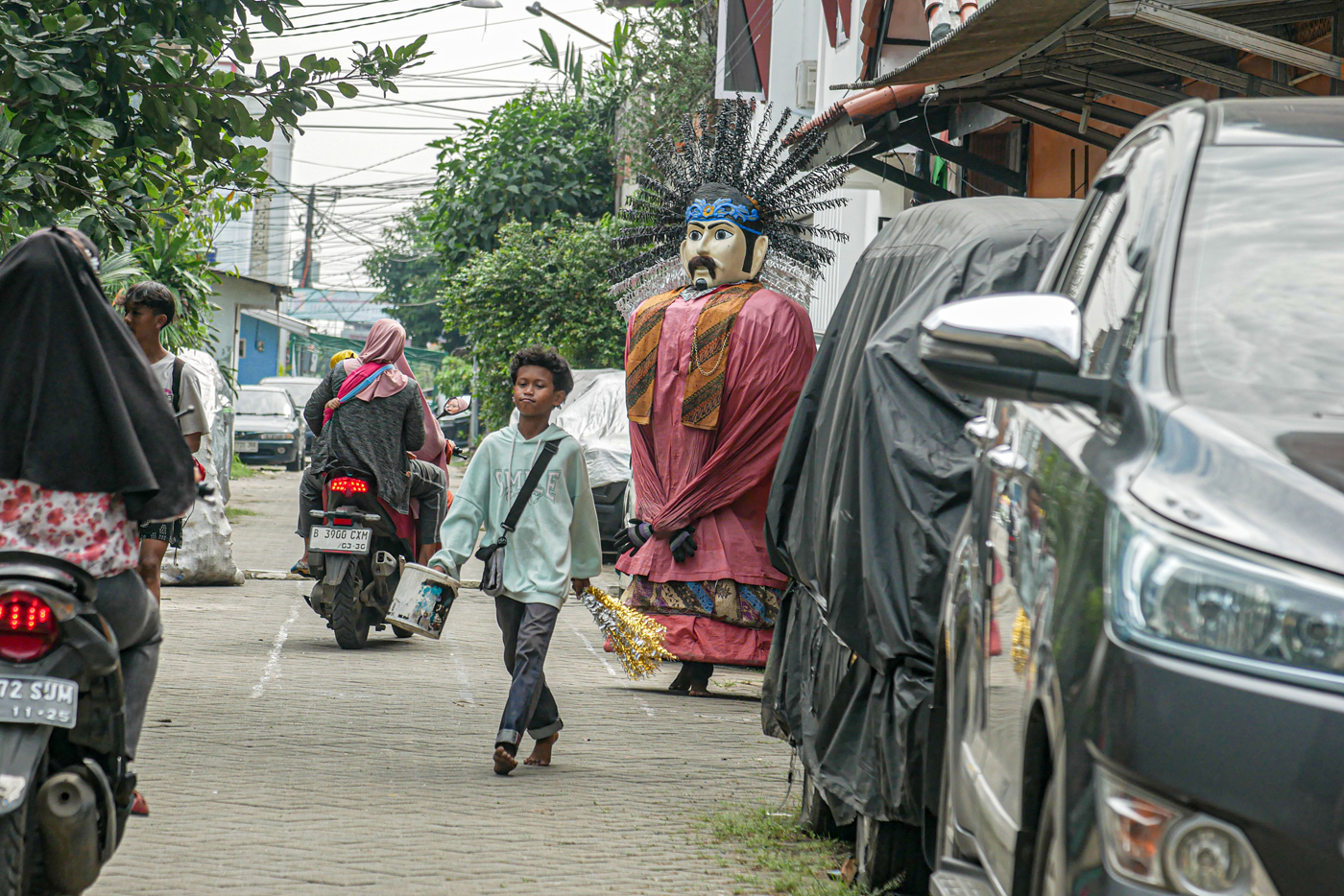 Seorang pengamen Ondel-Ondel melintas di daerah Cibodas, Kota Tangerang, Banten, Senin (19/5/2025).