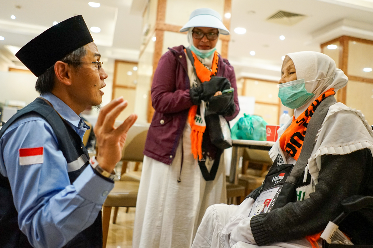 Wakil Ketua Komisi Nasional Disabilitas (KND) Deka Kurniawan berbicara dengan Junaina dan anaknya, Fatima Zahro CJH asal Jember yang sempat terpisah dengan ibunya. (Dhimas Ginanjar/JawaPos.com) - Image