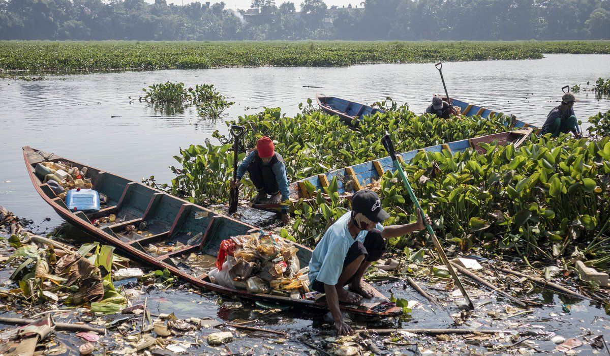 Warga tampak menggunakan perahu saat memungut sampah plastik dan eceng gondok di Sungai Citarum, Bandung, Jawa Barat pada Rabu (4/6). (Abdan Syakura-ANTARA) - Image