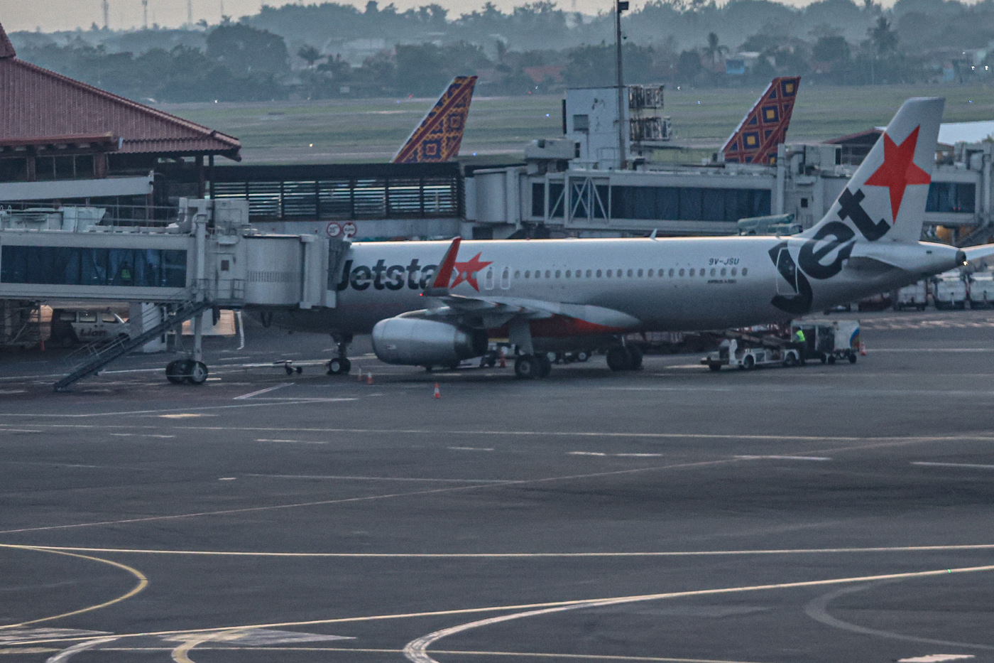 Pesawat Jetstar Asia terparkir di Terminal 2, Bandara Soekarno-Hatta, Tangerang, Kamis (12/6/2025).