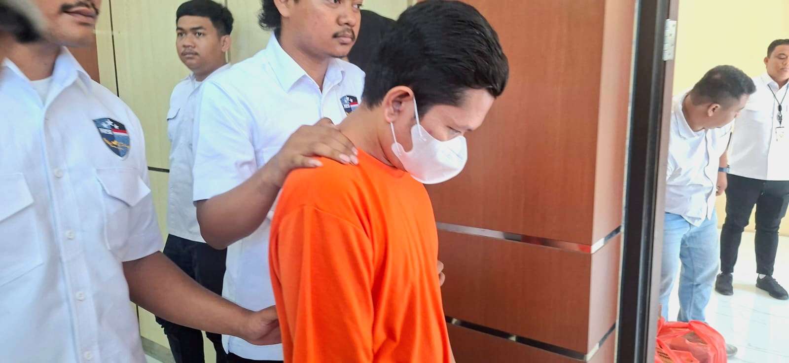 Tersangka TD (38), warga Prambon, Nganjuk, ditetapkan sebagai pelaku penyalahgunaan data pribadi untuk membuat 129 akun marketplace fiktif. (Juliana Christy/ JawaPos.com) - Image