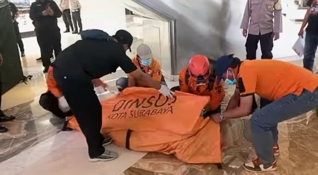 Petugas saat mengevakuasi jenazah pria yang tewas terjatuh di TP 5 Surabaya. (BPBD Surabaya) - Image