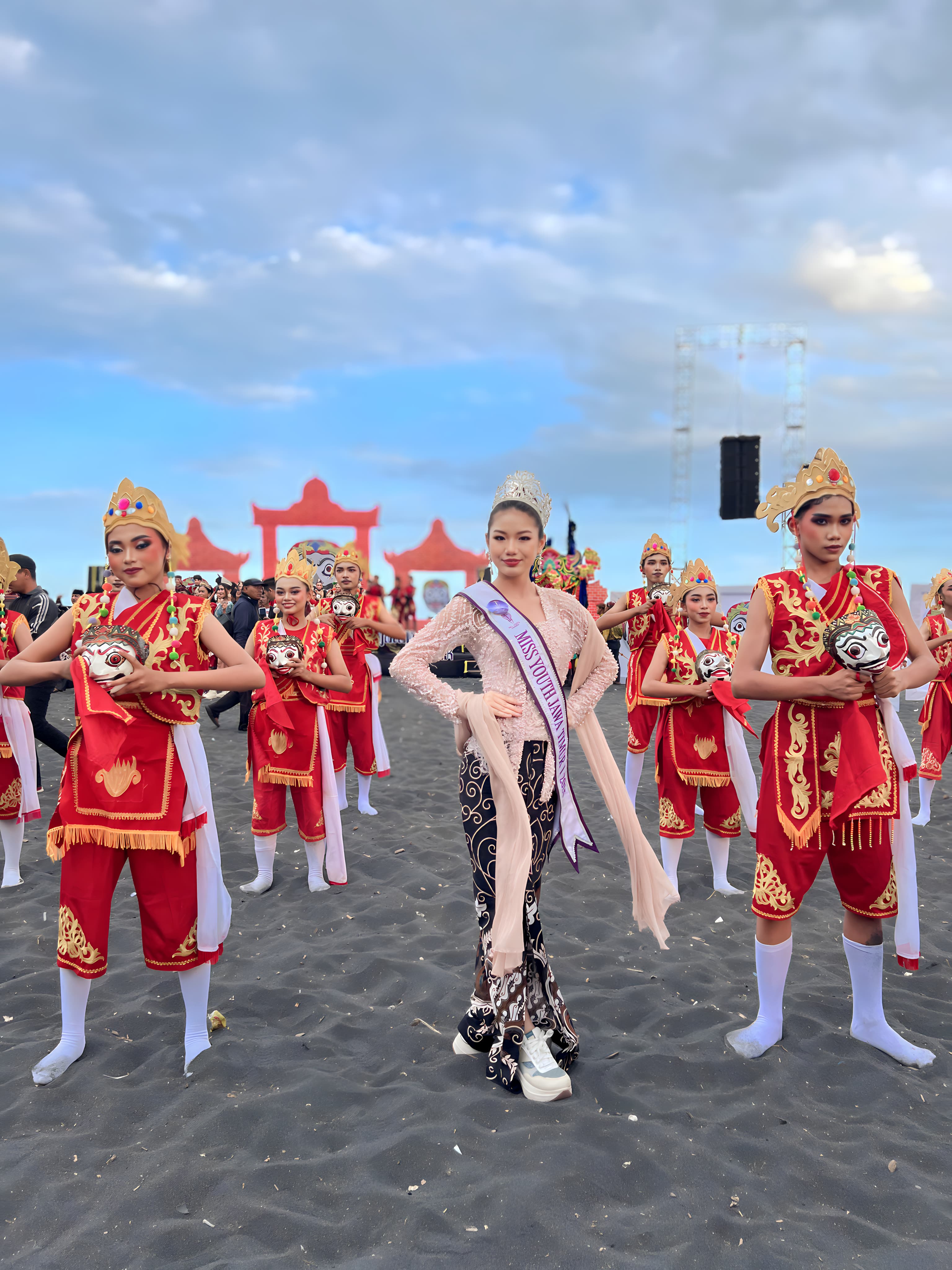 Jollene Ferischea, perwakilan Miss Youth Jawa Timur, bersama para penari topeng Segoro Topeng Kaliwungu di Pantai Watu Pecak, Lumajang, dalam ajang Kharisma Event Nusantara 2025. (Istimewa) - Image