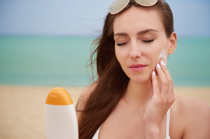 Ilustrasi, seseorang yang mengaplikasikan sunscreen pada wajahnya. Freepik/ gpointstudio. - Image