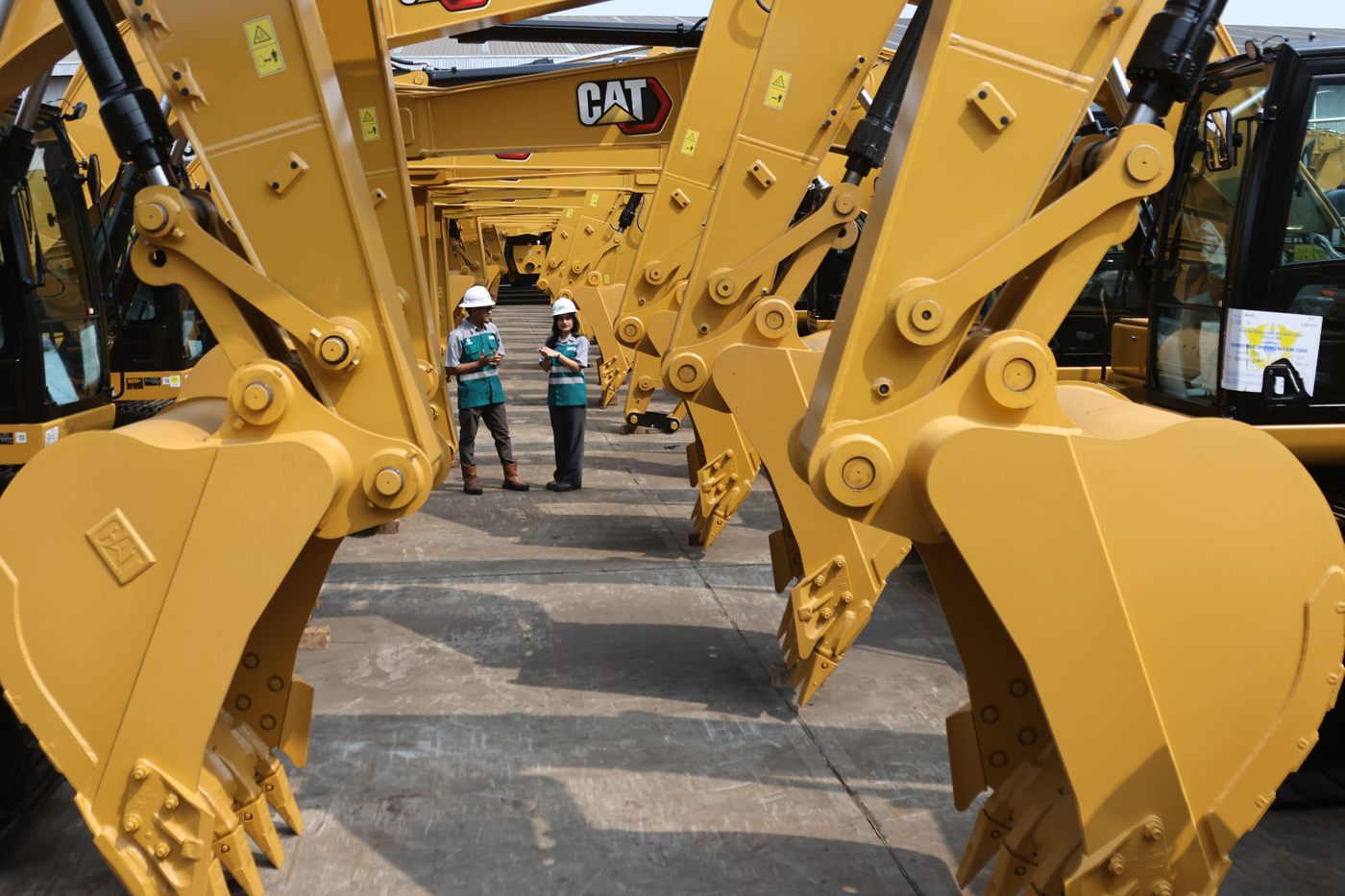 Pekerja mengecek sejumlah kendaraan tambang di open warehouse PT Cipta Krida Bahari (CKB), Cakung, J