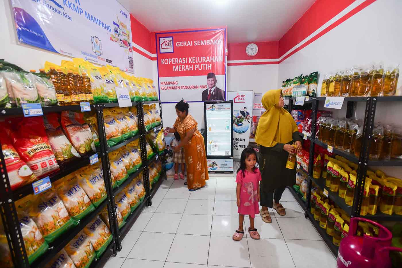 Warga membeli kebutuhan sehari-hari pada gerai sembako dan klinik kesehatan Koperasi merah Putih di