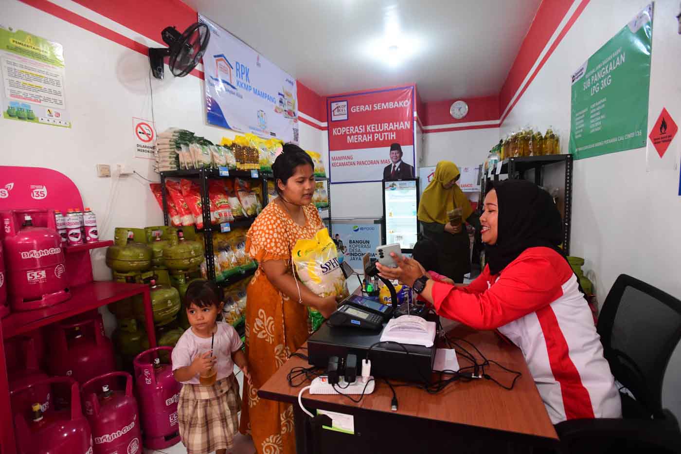 Warga membeli kebutuhan sehari-hari pada gerai sembako dan klinik kesehatan Koperasi merah Putih di