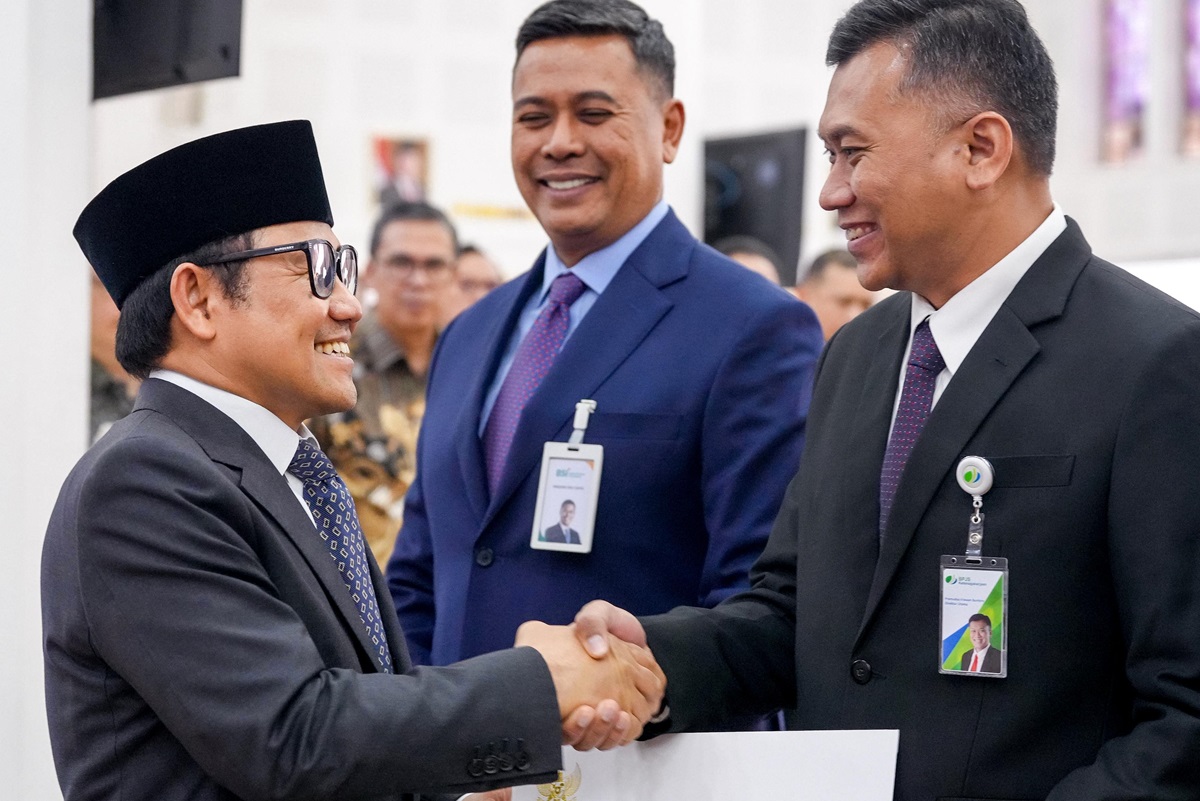 Menko PM Muhaimin Iskandar (kiri) menyerahkan Keppres 63/2025 kepada jajaran direski baru BPJS Ketenagakerjaan, Rabu (23/7). (dok: HUmas Kemenko PM) - Image