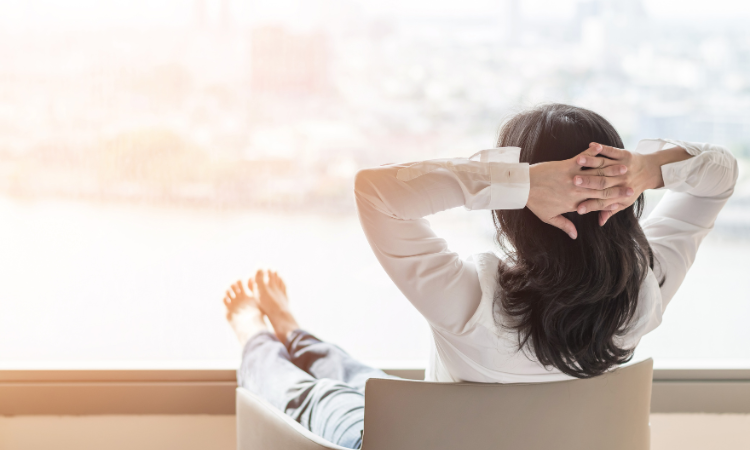 Seorang perempuan dewasa duduk santai sambil menatap ke luar jendela, mencerminkan ketenangan batin dan kepercayaan diri setelah berani menetapkan batasan pribadi. (Dok. Canva) - Image