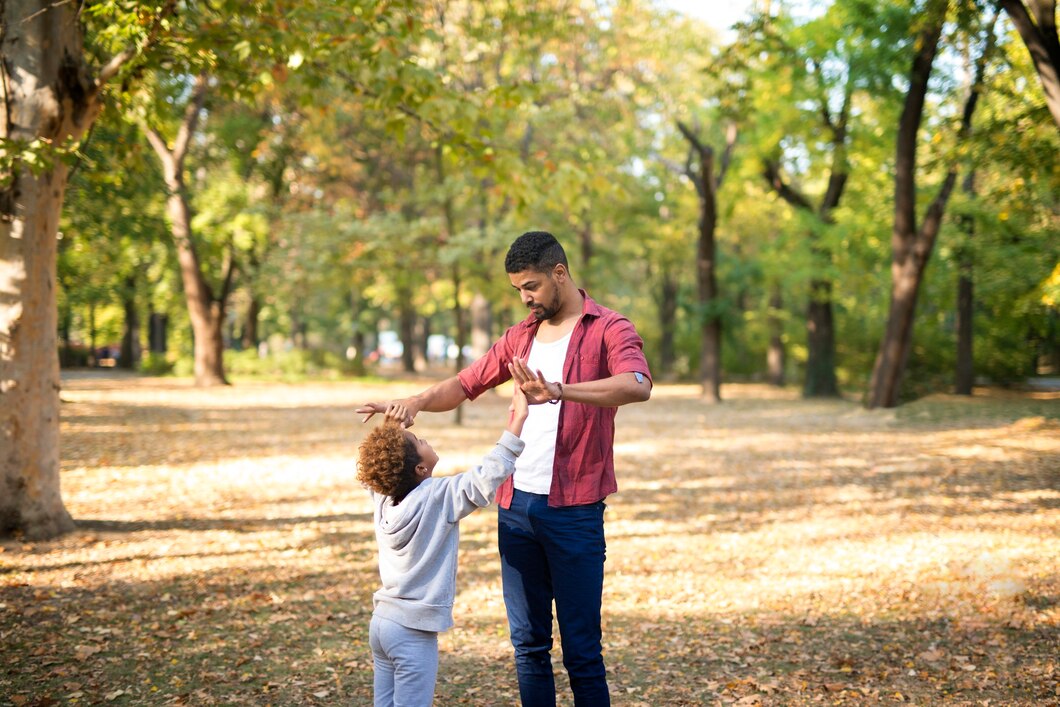 Seorang ayah dan anak yang sedang berinteraksi dengan penuh perhatian dan kasih sayang, menunjukkan hubungan yang saling menghormati. (Freepik) - Image