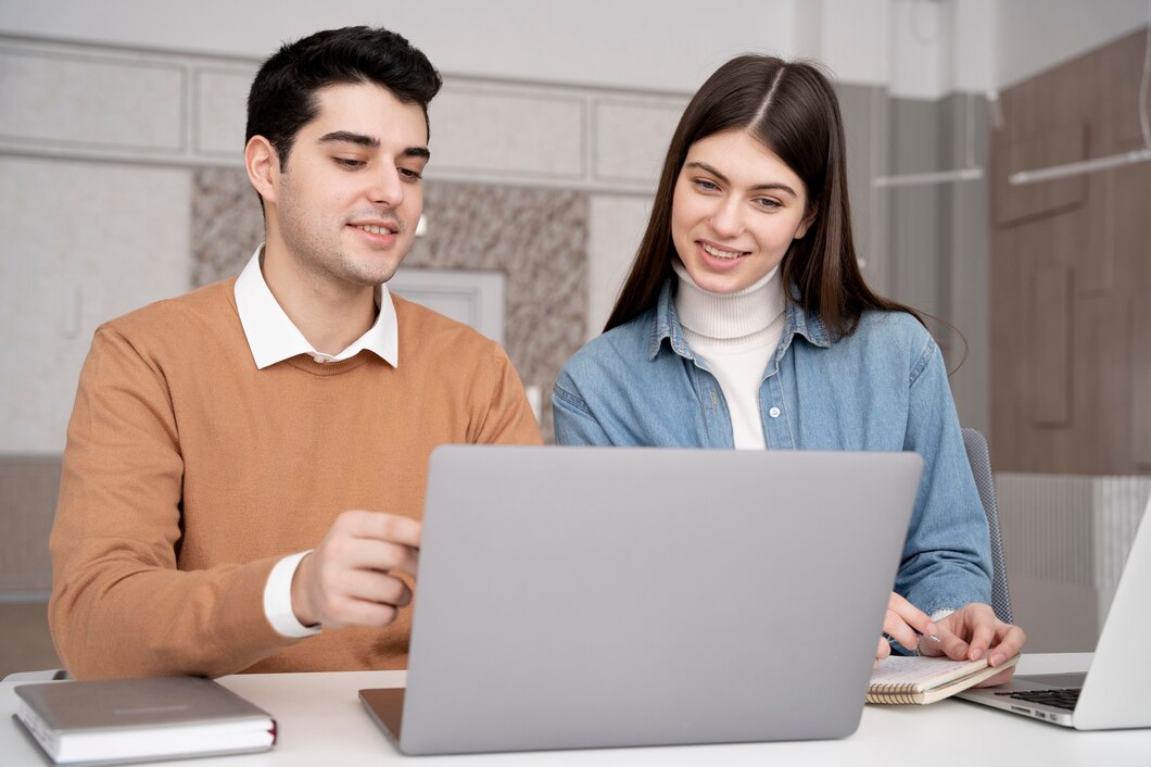Ilustrasi seorang pria dan wanita yang sedang melihat laptop, menunjukkan fokus pada perencanaan keuangan dan investasi, bukan pada pembelian barang mewah./Freepik - Image