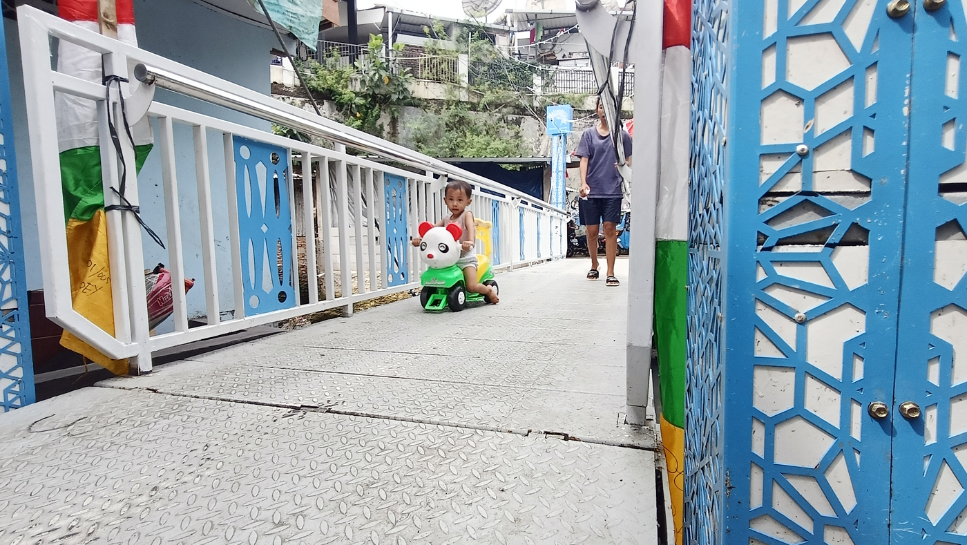 Anak kecil melintas di Jembatan Antar Kampung (JAK) Angkat Mulia, Gandaria, Jakarta, Selasa (19/8/20