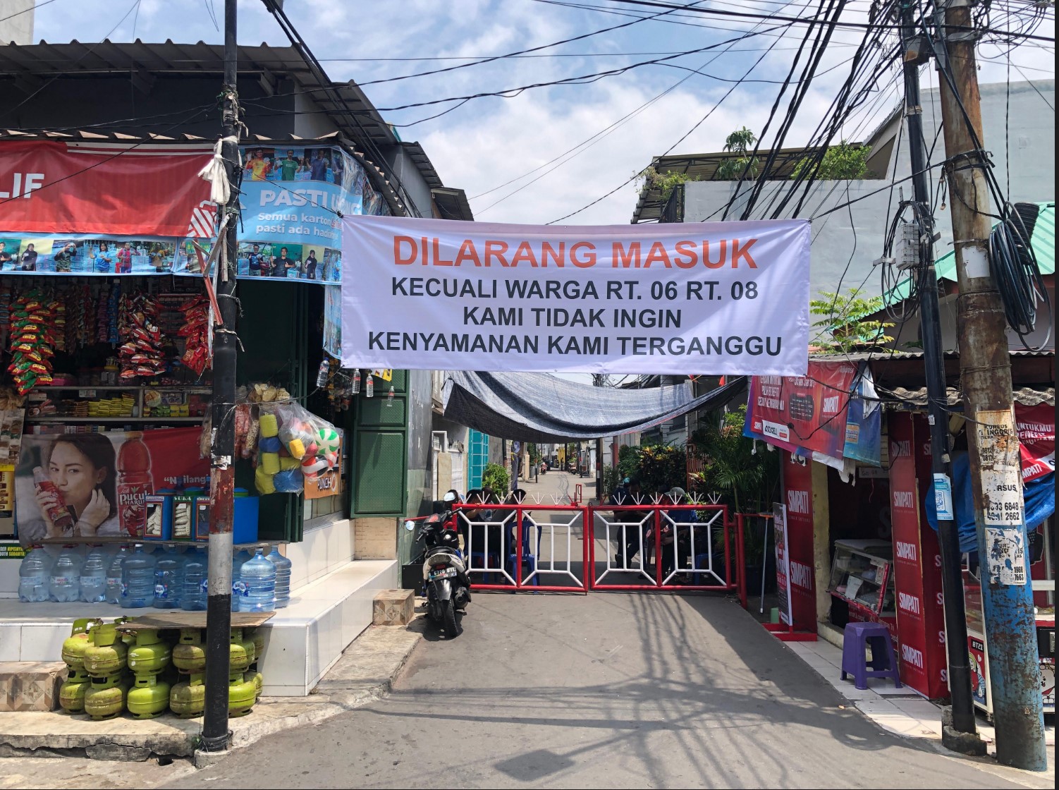 Warga dan aparat keamanan berjaga di sekitar rumah politisi Partai NasDem Ahmad Sahroni pada Selasa (2/9). (Syahrul Yunizar/JawaPos.com) - Image