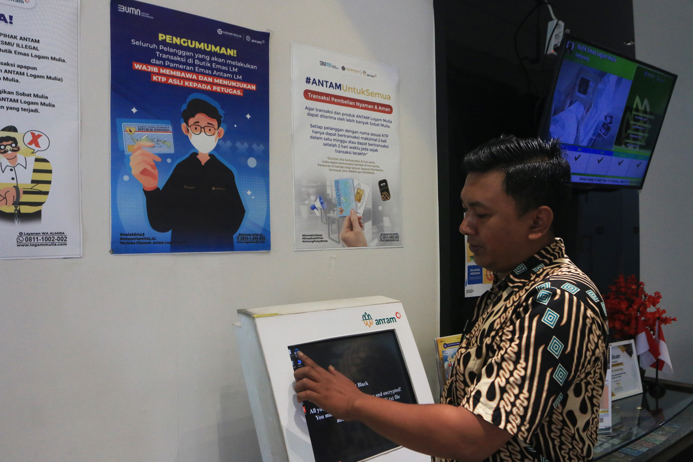 Petugas Butik Emas Logan Mulia Antam menunjukkan replika logam mulia keluaran PT ANTAM di butik emas