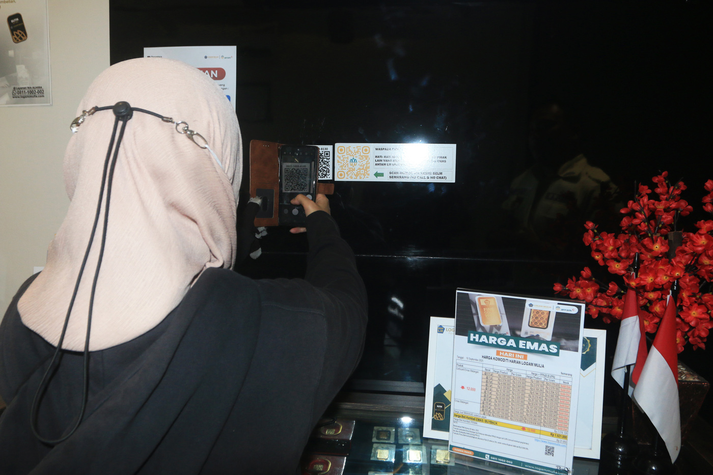 Petugas Butik Emas Logan Mulia Antam menunjukkan replika logam mulia keluaran PT ANTAM di butik emas