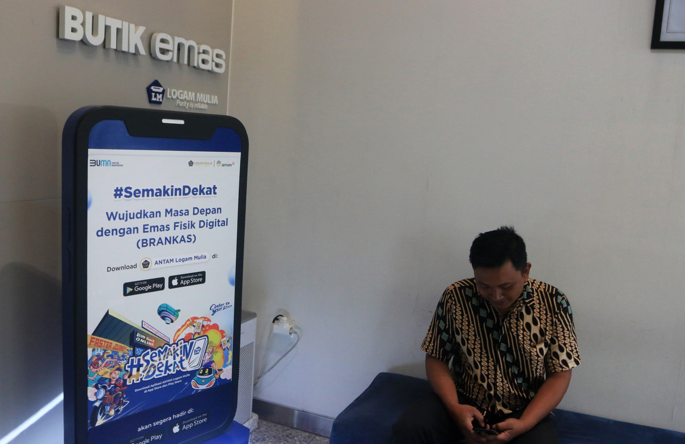 Petugas Butik Emas Logan Mulia Antam menunjukkan replika logam mulia keluaran PT ANTAM di butik emas