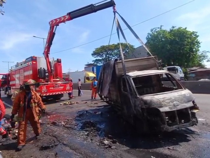 Petugas Pemadam Kebakaran saat berjibaku menangani mobil box yang terbakar di Tol Dupak Surabaya. (Dokumentasi CC 112 Surabaya) - Image