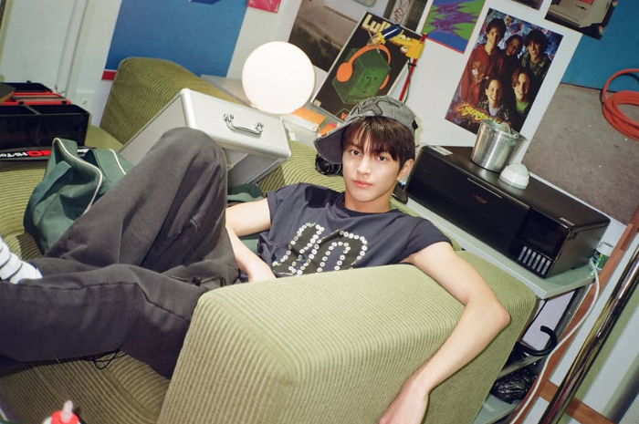 Keonho dengan topi miring berpose duduk santai di sofa. (Instagram @cortis)
