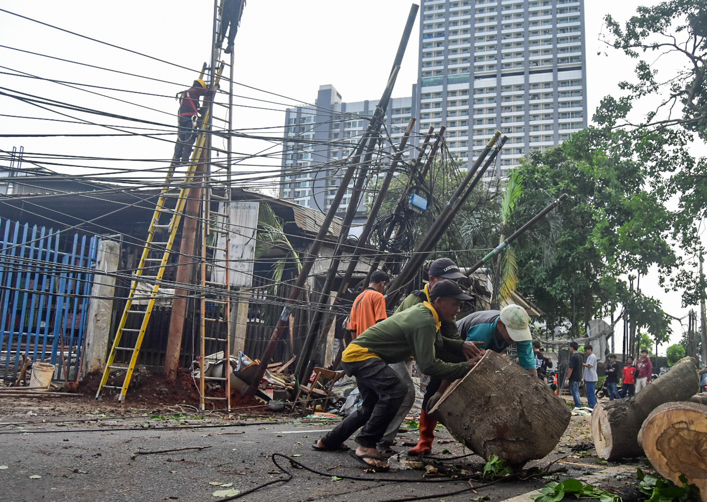 Petugas memotong batang pohon tumbang yang menutupi Jalan Jombang Raya, Pondok Aren, Tangerang Selat