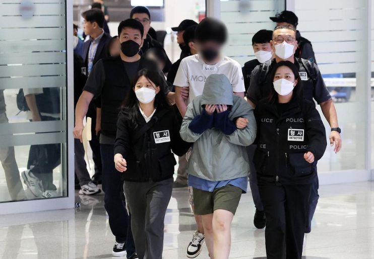Warga Korea Selatan yang ditangkap di Kamboja tiba di Bandara Internasional Incheon dengan pengawalan polisi (18/10). (Joint Press Corps) - Image