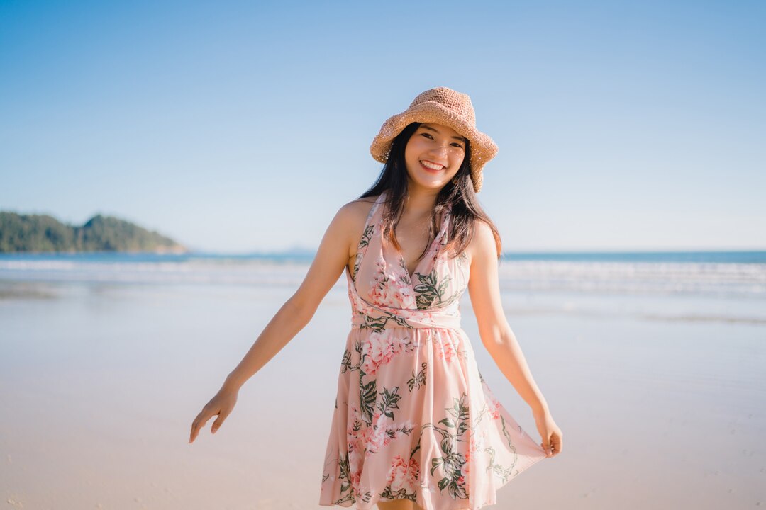 ilustrasi seorang wanita yang berdiri di tepi pantai dengan tersenyum, menyambut kebebasan setelah melepaskan beban emosional masa lalu. (Freepik) - Image