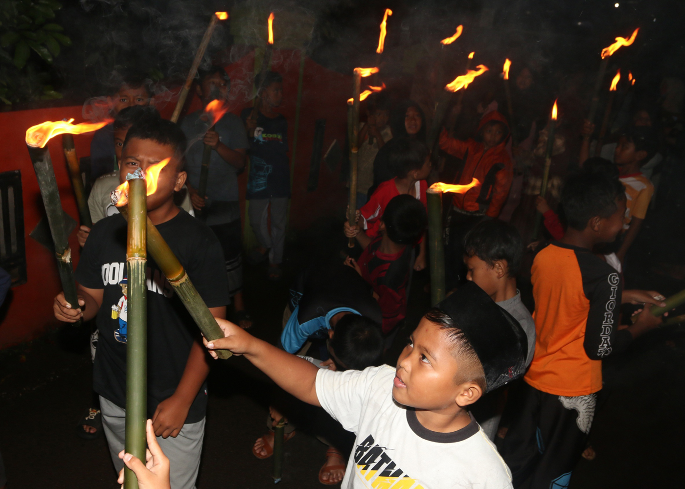 Sejumlah warga mengenakan pakaian tradisional membawa obor dan kendi berisi air dari sendang saat tr