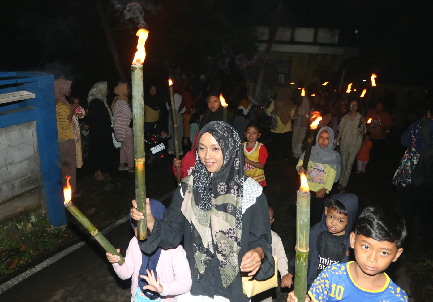 Sejumlah warga mengenakan pakaian tradisional membawa obor dan kendi berisi air dari sendang saat tr