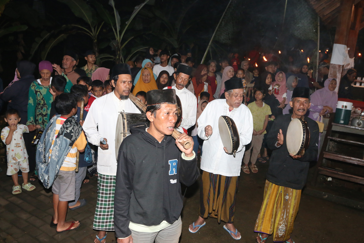 Sejumlah warga mengenakan pakaian tradisional membawa obor dan kendi berisi air dari sendang saat tr
