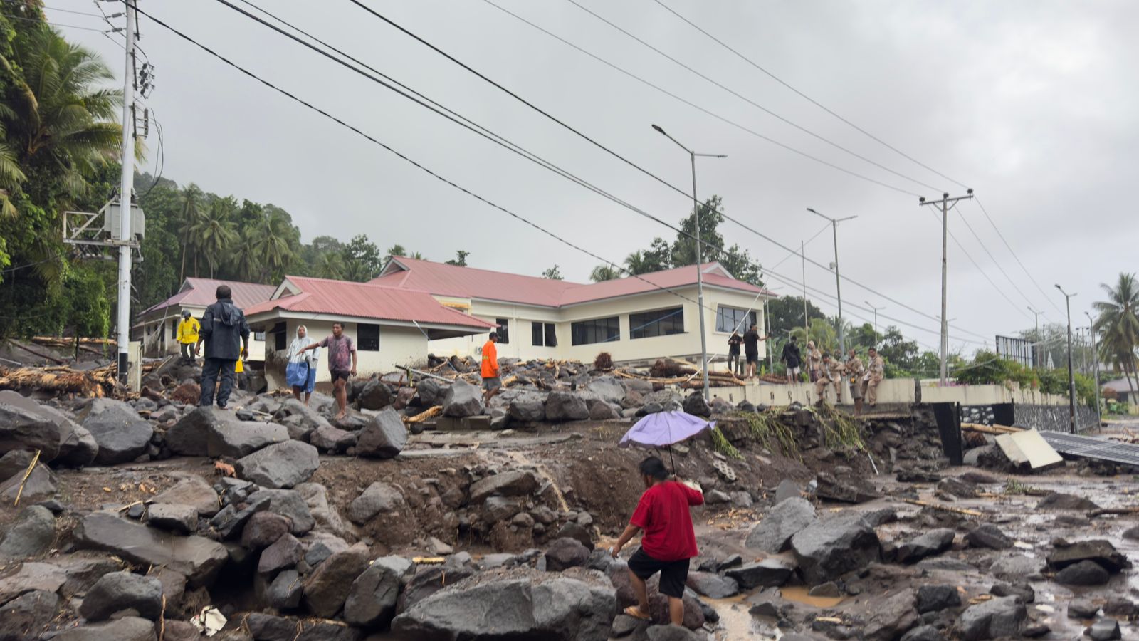 Material batu-batuan memenuhi jalanan pascabanjir bandang yang menerjang 3 kecamatan di di Kabupaten Kepualauan Sitaro pada Senin (5/1). (BPBD Kabupaten Kepulauan Sitaro) - Image