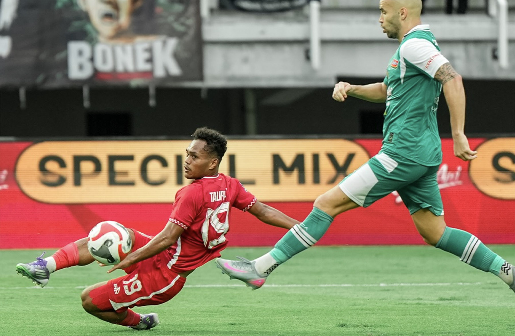 Winger Malut United Taufik Rustam (kiri) duel dengan bek Persebaya, Risto, di GBT. (Dok. Malut) - Image