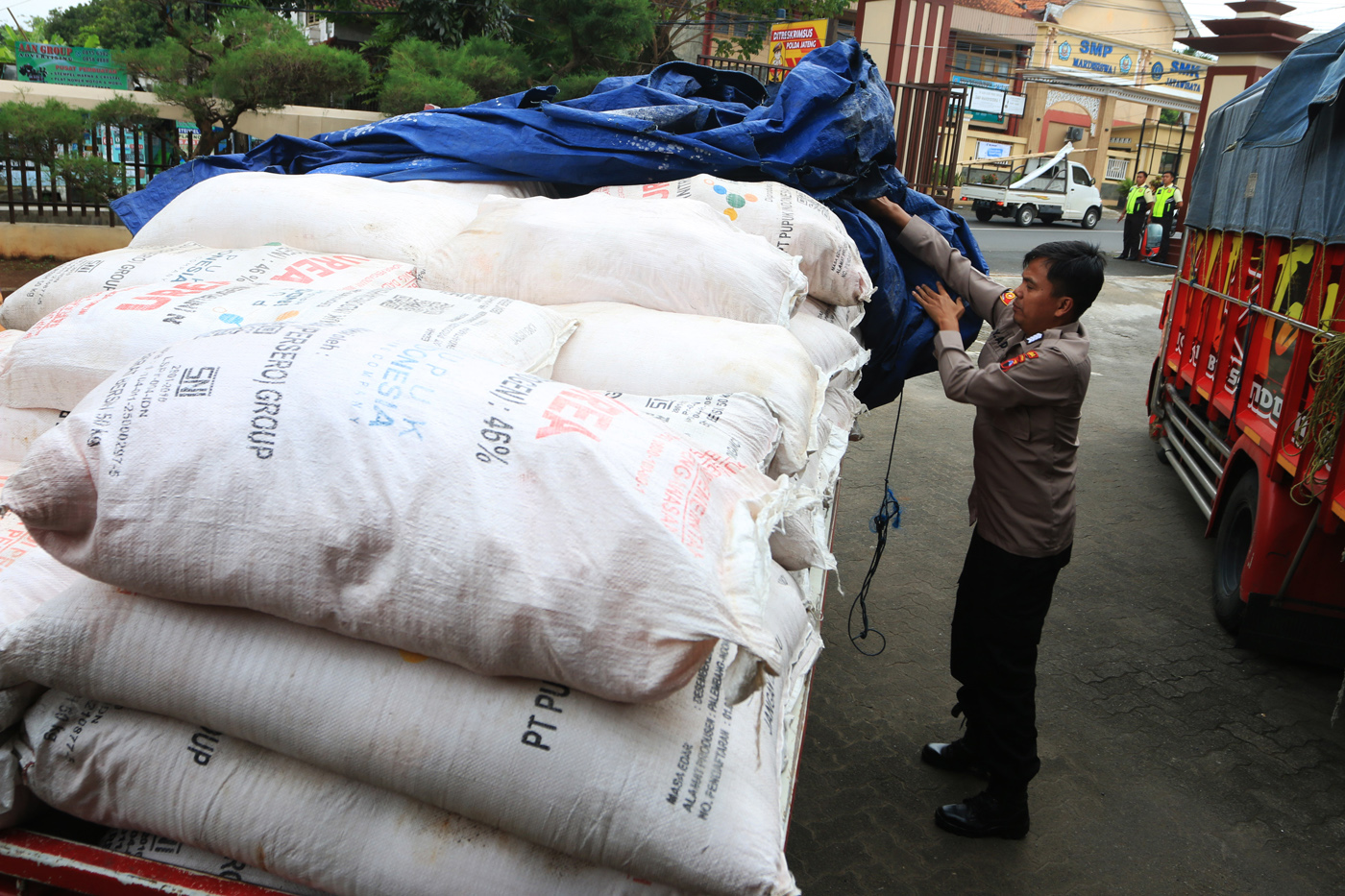 Petugas kepolisian memasukkan barang bukti berupa pupuk subsidi ke dalam truk seusai rilis pengungka