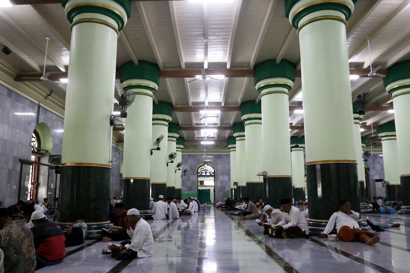 Sejumlah warga menyimak bacaan Al Quran yang disampaikan oleh seorang hafidz (penghafal) saat mengik