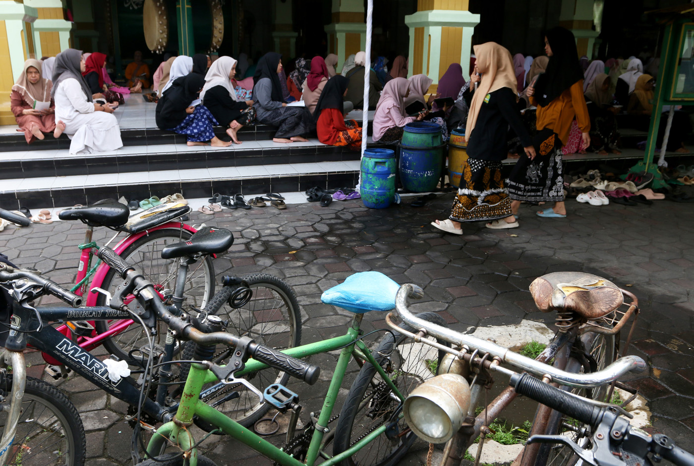 Sejumlah warga menyimak bacaan Al Quran yang disampaikan oleh seorang hafidz (penghafal) saat mengik
