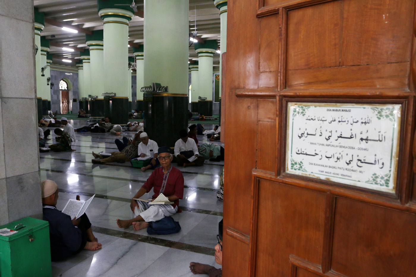 Sejumlah warga menyimak bacaan Al Quran yang disampaikan oleh seorang hafidz (penghafal) saat mengik