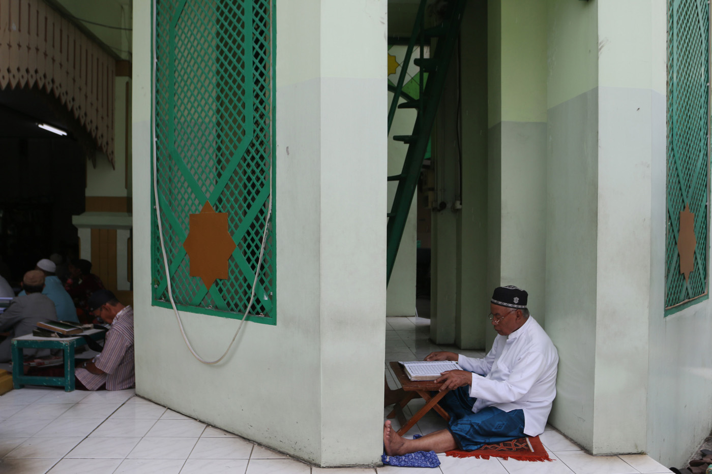 Sejumlah warga menyimak bacaan Al Quran yang disampaikan oleh seorang hafidz (penghafal) saat mengik