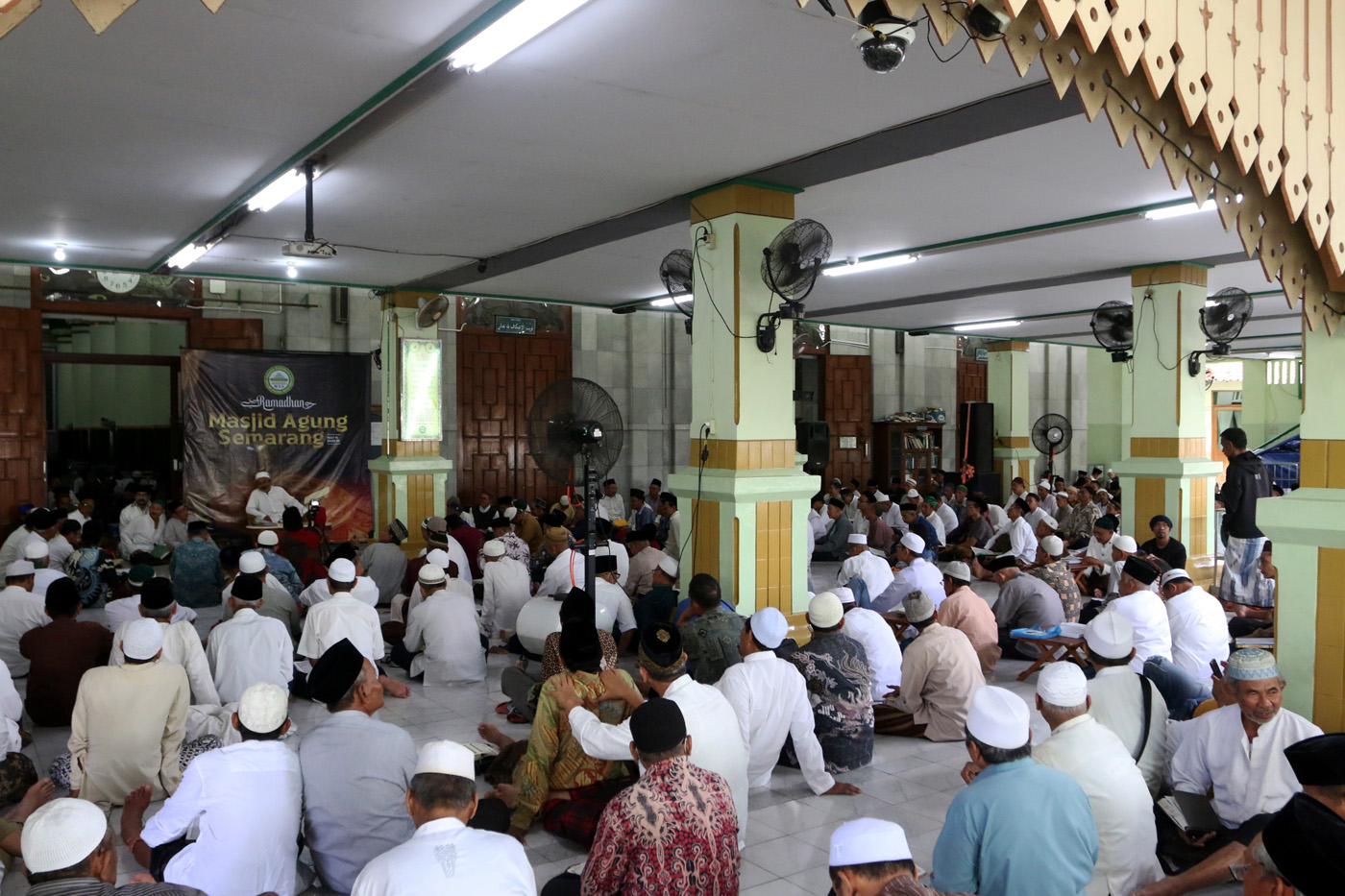 Sejumlah warga menyimak bacaan Al Quran yang disampaikan oleh seorang hafidz (penghafal) saat mengik