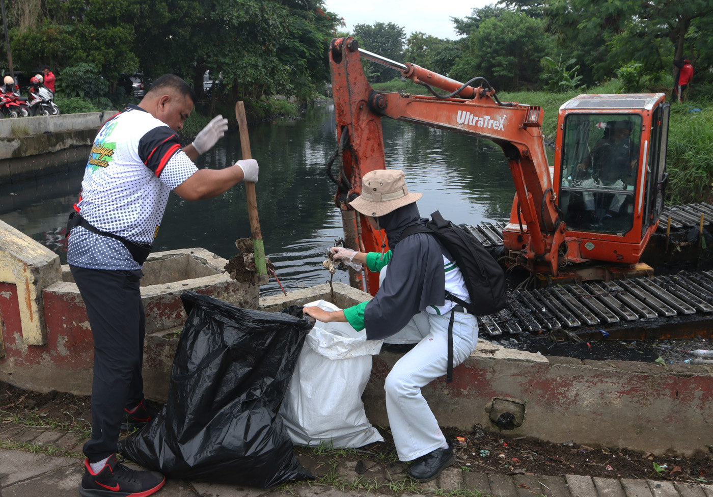 Petugas kebersihan bersama warga bergotong royong membersihkan sungai dari sampah dan sedimentasi di