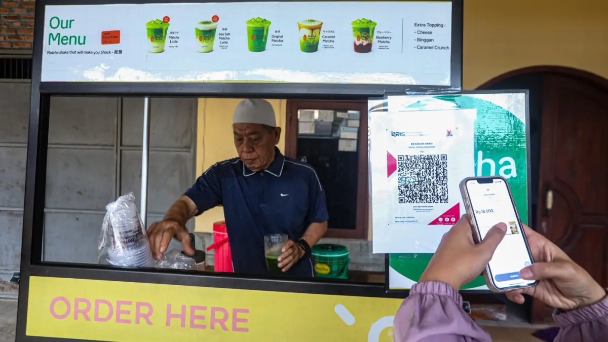 Warga membayar menggunakan kode batang QRIS di salah satu gerai UMKM di Depok, Jawa Barat, Rabu (25/2/2026). (Salman Toyibi/Jawa Pos)