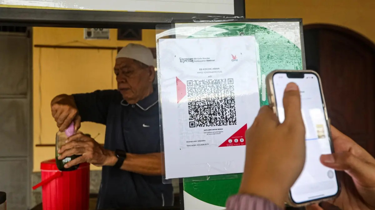 Warga membayar menggunakan kode batang QRIS di salah satu gerai UMKM di Depok, Jawa Barat, Rabu (25/2/2026). (Salman Toyibi/Jawa Pos)