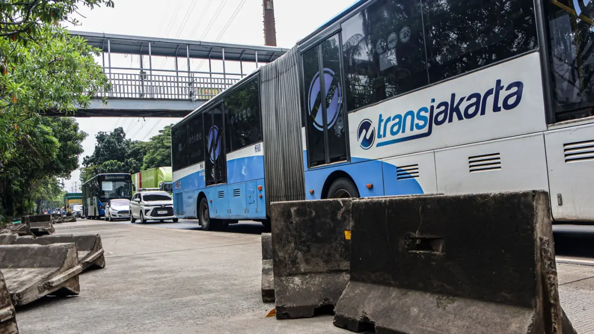 Pengendara melintas di samping pembatas jalur Transjakarta berantakan pasca banjir yang menggenangi jalan Daan Mogot, Jakarta, Senin (9/3/2026). (Hanung Hambara/Jawa Pos)