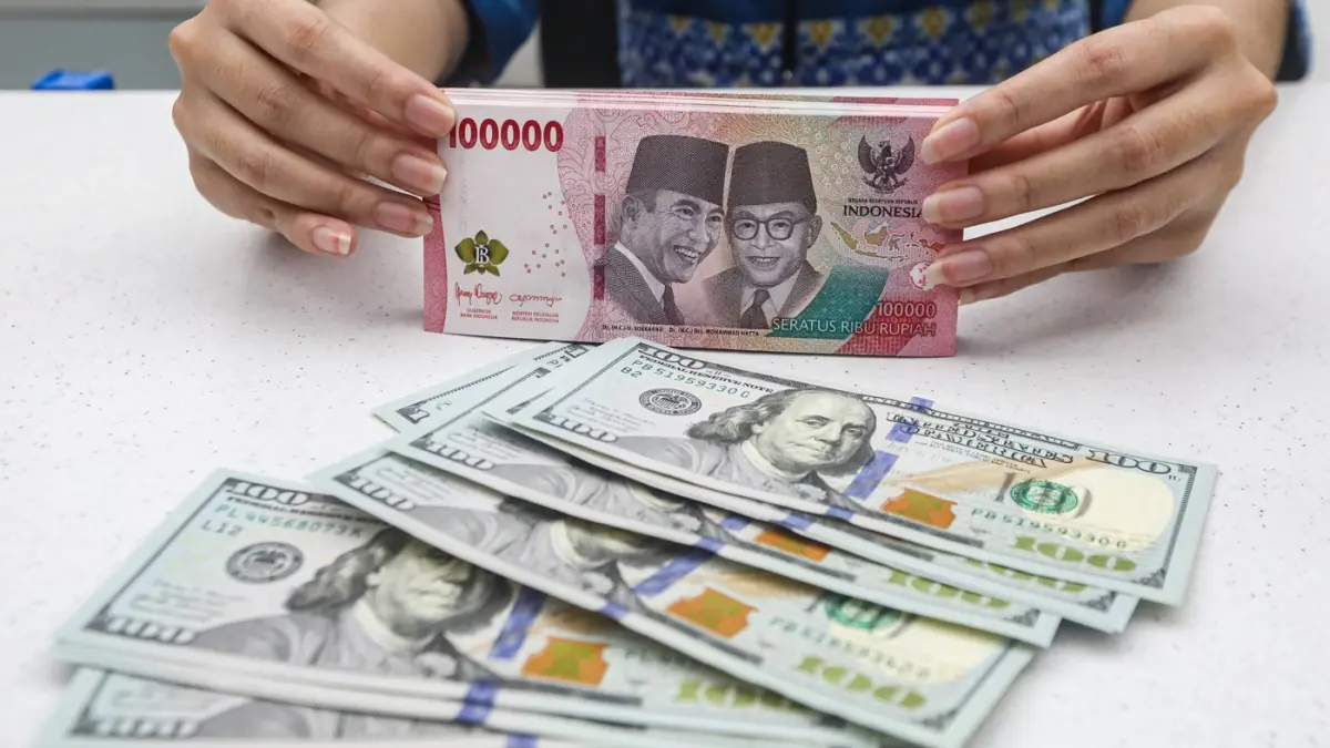 Teller menunjukan mata uang Dolar AS dan Rupiah di salah satu kantor cabang Bank Mandiri di Jakarta, Senin (9/3/2026). (Salman Toyibi/Jawa Pos)