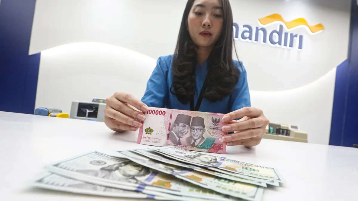 Teller menunjukan mata uang Dolar AS dan Rupiah di salah satu kantor cabang Bank Mandiri di Jakarta, Senin (9/3/2026). (Salman Toyibi/Jawa Pos)